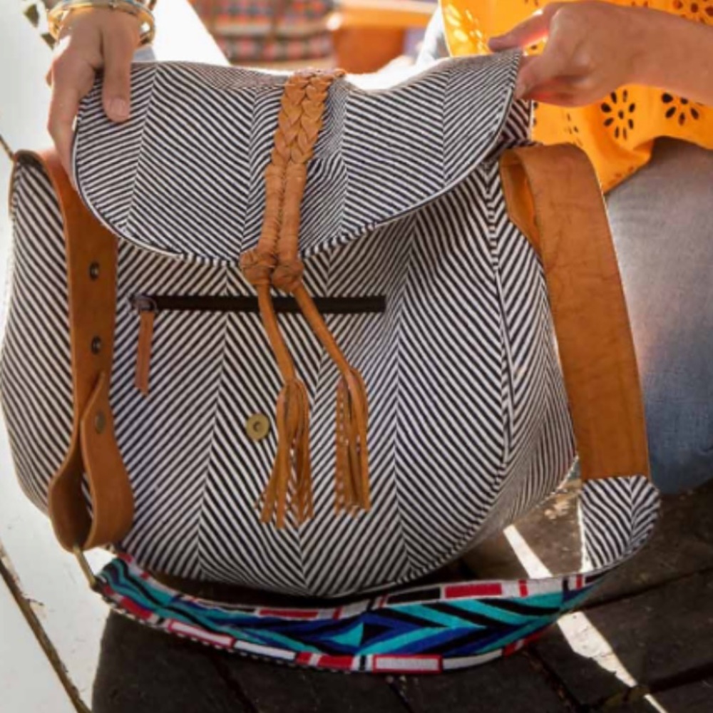 Like new Noonday bag with tassel, zipper closure and adjust strap.